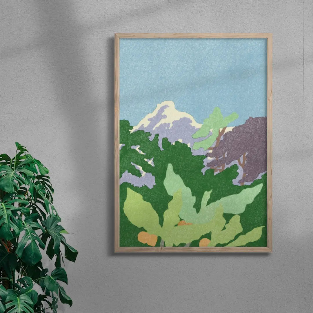 Framed artwork of a mountain and trees on a gray wall with a plant beside it.