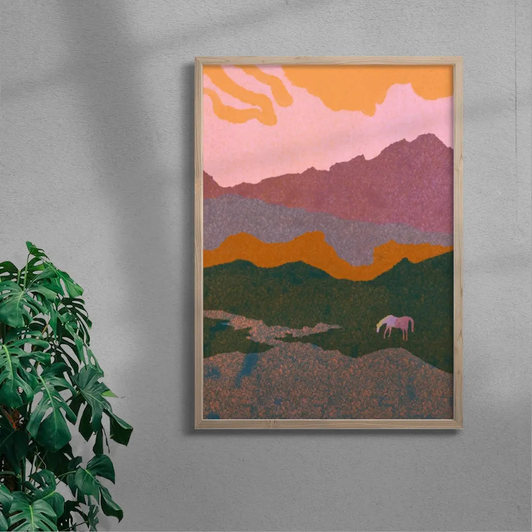 Framed abstract landscape art with a pink and orange sky and green mountains on a gray wall.